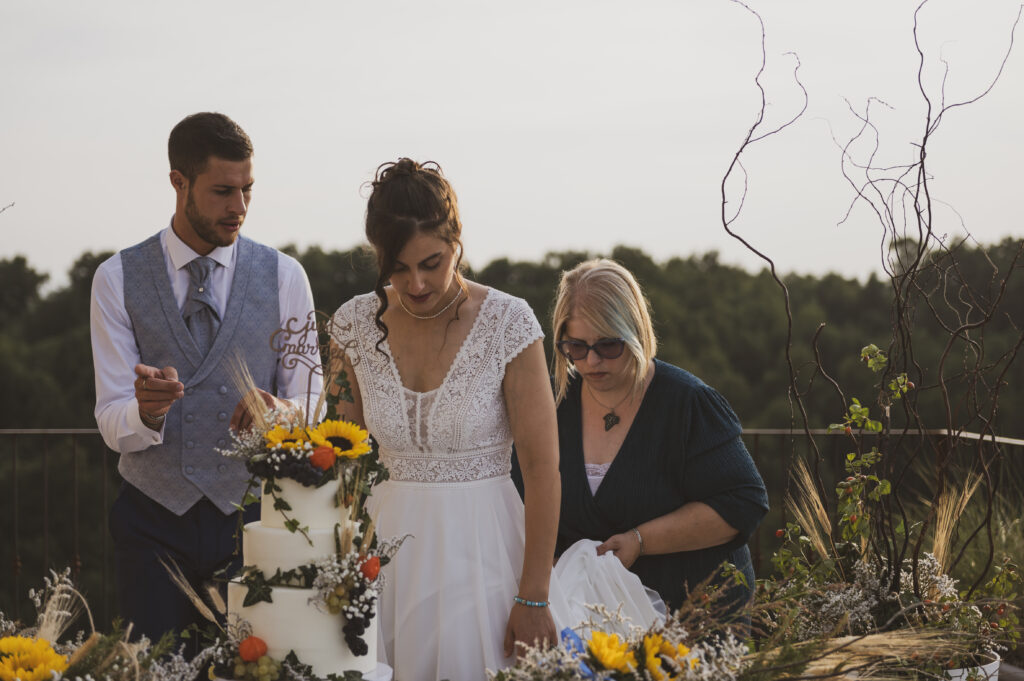 Sposi e wedding planner dietro la torta nuziale