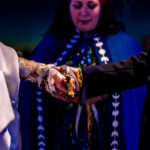 mani che si legano nel rituale del legamento delle mani per un matrimonio con rito simbolico